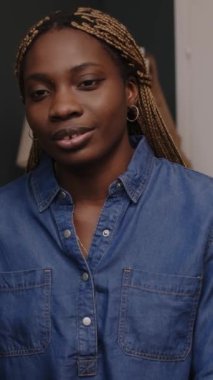 Genç, güzel siyahi bir kadının mesai arasında iş arkadaşlarıyla sohbet ederken çekilmiş dikey bir fotoğrafı.