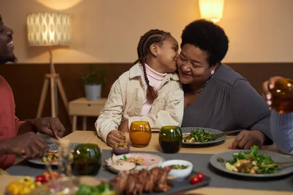 Portrait African American Little Girl Kissing Grandma Cheek Dinner Table — Stock Photo, Image