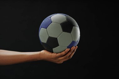 Futbol topunu fotokopi alanı ile siyah zemin üzerinde tutarken minimum yakın çekim