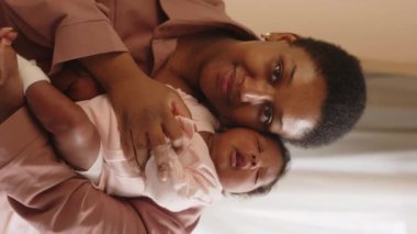 Kamera önünde bebek gibi poz veren mutlu siyah bir kadının dik bel portresi.