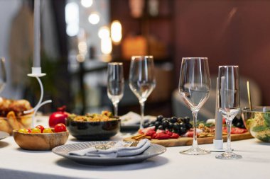 Boş flüt grubu, katlanmış pamuk peçeteli tabak ve diğer atıştırmalıklara karşı servis edilen salamura domatesli ahşap kase.