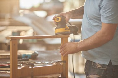 Tanınmayan kaslı adamın güneş ışığında ahşap mobilyalar inşa edişini kapatın, boşluğu kopyalayın.