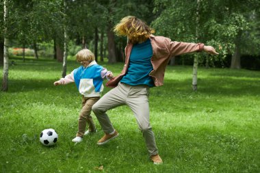 Küçük çocuğun babasıyla parkta futbol oynarken, fotokopi çekimleri.