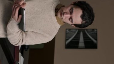 Modern bilişim ofisinde dijital tabletli genç erkek programcının dikey portresi.