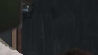 Modern ofiste şirket projesini geliştirirken masanın etrafında oturan ve tartışan genç yaratıcı erkek ve kadın bilişim uzmanlarının dikey bel yüksekliği