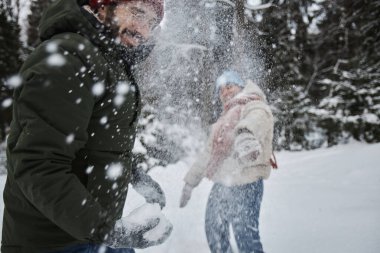 Mutlu genç bir çiftin portresi. Kışın dışarıya kartopu atıp eğleniyorlar.