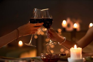 Akşam yemeğinde şarap bardaklarıyla kadeh kaldıran iki genç kadının Noel ışıklarıyla, fotokopi çekilen