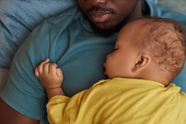 Üst görüntüde, babanın göğsünde uyuyan sevimli küçük bebeğin yakın çekimi, kopyalama alanı