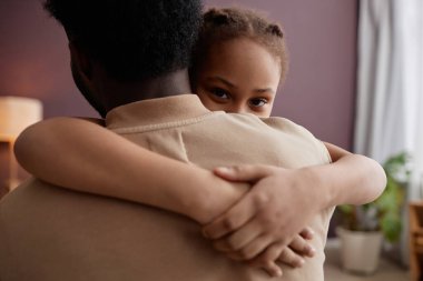 Mutlu bir babanın kucağında küçük tatlı bir kızın kamera karşısında babasının kucağına oturması.