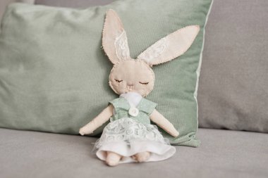 El yapımı tavşancık oyuncağı kanepeye oturmuş, dantelli elbise giyiyor, fotokopi odası.
