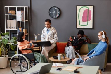 Modern ofiste iş görüşmesinde engelli olan çeşitli gençler var.