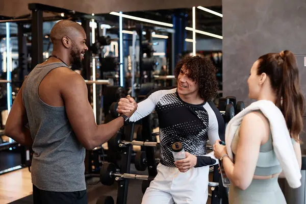 Spor salonunda tokalaşan bir grup genç birlikte antrenmanların keyfini çıkarıyorlar.