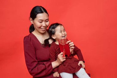 Kızıl Çin yeni yıl geleneği ve kahkahalarına karşı elinde Hongbao zarfı olan genç bir kadının belden yukarı portresi her yıl bol miktarda bulunur.