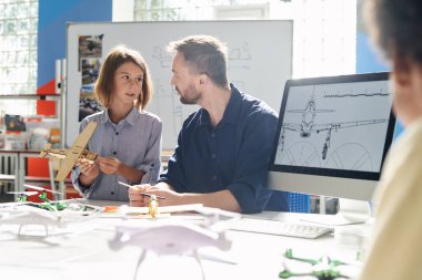 Okul çocuğu ahşap detaylardan uçak montajı için öğretmenden yardım istedi.