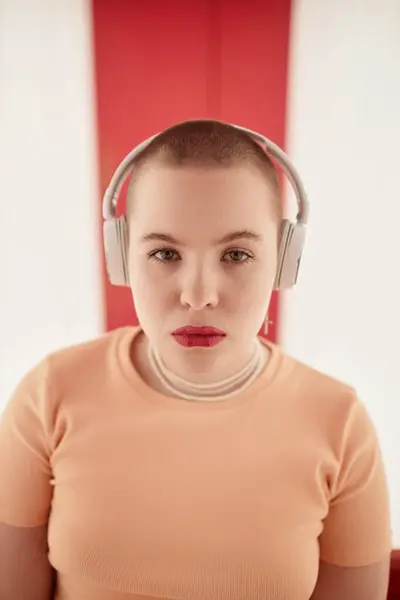 stock image Graphic portrait of gen Z young woman wearing headphones and looking at camera with confidence in futuristic space