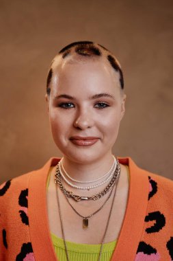 Kameraya gülümseyen çita desenli genç bir kadının dikey portresi.