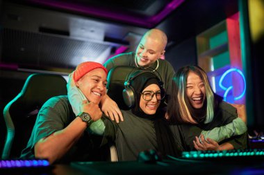 Diverse team of female gamers celebrating victory in cybersports competition and cheering clipart