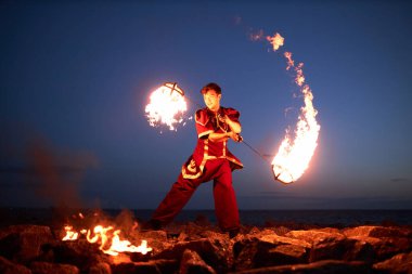 Gece vakti ateş püskürten genç adamın tam boy portresi, boşluğu kopyala.