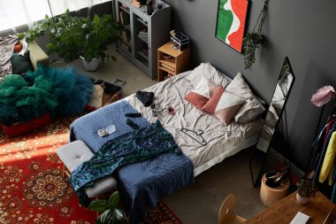 Üst manzara arkaplan resmi. Dağınık kızlar odası, yatakta parti kıyafeti, kopyalama alanı.