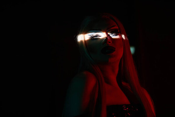 Детальный снимок трансвестита на сцене в темноте с акцентом на глаза, копия пространства