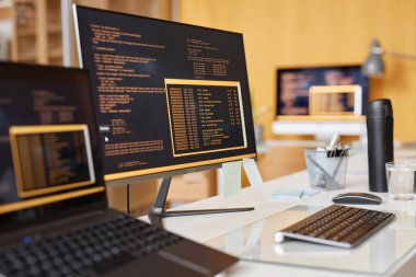 IT geliştirme ofisindeki iş yerinde renkli kod satırları olan bilgisayar ekranının arkaplan resmini kapat, alanı kopyala