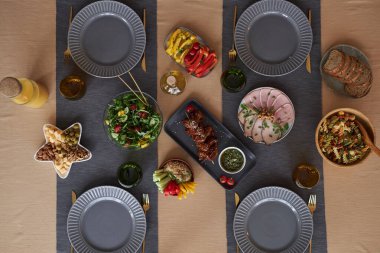 Tozlu mavi tabaklarla yemek masasının üst görüntüsü ve rahat kutlama alanı için masa koşucuları.