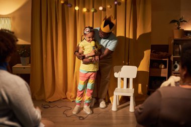 Tam boy boy portresi. Şirin siyahi kız sahne sahnesinde babasının fotokopi aletiyle oynuyor.