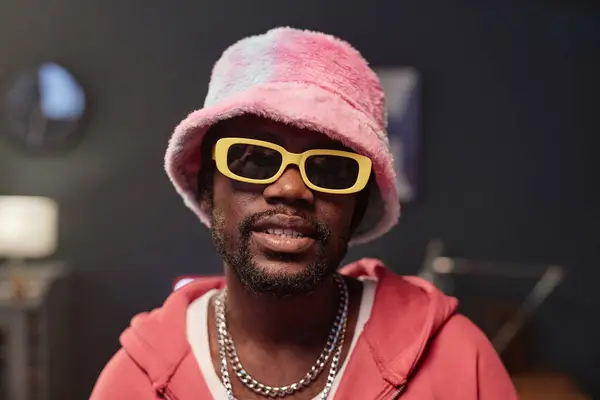 stock image Closeup portrait of African American man wearing pink outfit and fur hat looking at camera with dramatic lighting