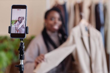 Moda tasarımcısı olarak genç siyahi bir kadının portresi akıllı telefon ekran kopyalama alanı odaklı online alışveriş deneyimi için videolar kaydediyor