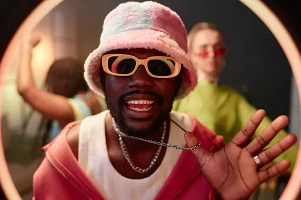 stock image Front view portrait of African American young man as hip-hop artist rapping to camera and recording video for social media with ring light frame