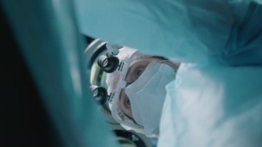 Kafkasyalı yetişkin kadın doktorun ameliyat odasında çalışırken büyüteç taktığı alttaki fotoğraf.