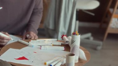 Kafkasyalı bir adamın ergen oğlu ile resim çektirirken renkli sayfaları pastel boyayla boyayıp evde boş vakitlerini birlikte geçirirken sohbet ederken.