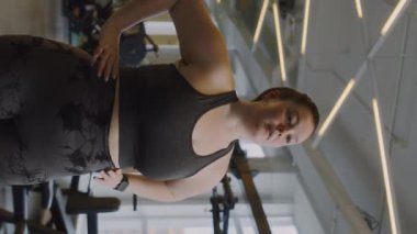 Aktif giyimli, boynu ve bilekleri ısınan, spor yaparken boynu ve bilekleri ısınan beyaz bir kadının orta boy fotoğrafı.