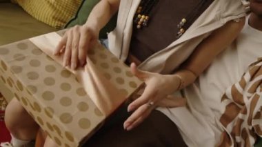 Sevgilisini yeni saç kurutma makinesiyle hediye kutusunu açarken yanağından öptüğü videoyu kaydeden mutlu bir adamın el bilgisayarı.