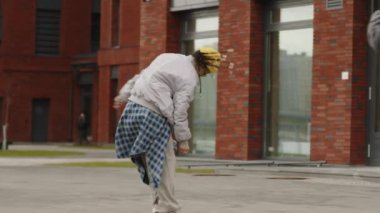 Sevgilisi akıllı telefondan video kaydederken hippi kıyafeti giymiş, hip hop dansı yapan iki ırklı kızın yavaş çekimleri.