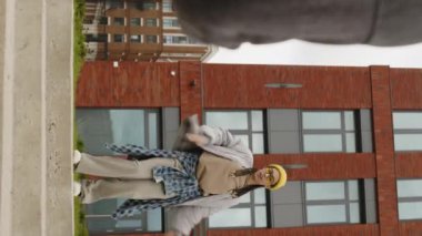 Serin bir bahar gününde sokakta dans eden havalı, çift ırklı hippi kız hip hop 'un dikey çekimi.