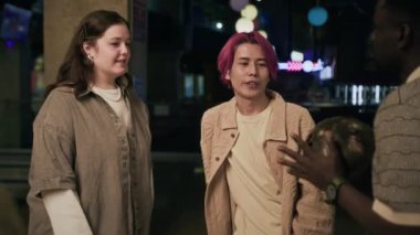 Orta boy Afro-Amerikalı adamın çeşitli erkek ve kadın jenerasyon arkadaşlarıyla bowling salonunda takıldığı bir fotoğraf.