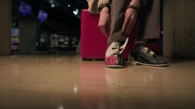 Bowling ayakkabılarını denerken, bovling turnuvasına hazırlanan tanınmamış erkek bovling oyuncusunun alt kısmı.