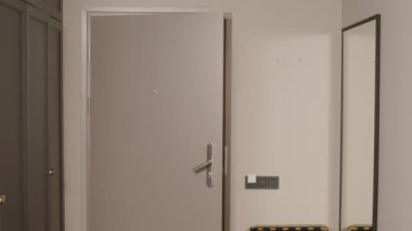 Orta yaşlı yakışıklı Orta Doğulu erkek girişimci otel odasına giriyor ve şık bir takım elbise ve kravat takıyor.