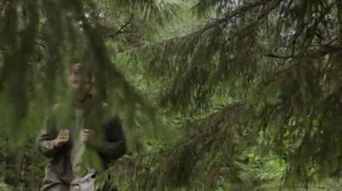 Kafkasyalı bir adamın gündüz vakti ormanda yürürken sırtında sırt çantası taşırken orta boy fotoğrafı.