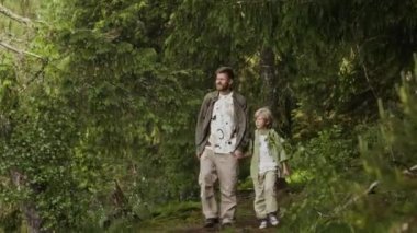 9 yaşında oğlu olan beyaz bir baba gündüz vakti nehirle ormanda yürürken yaz doğasının tadını çıkarıyor.