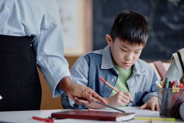 Tanımlanamayan bir öğretmeni olan genç Asyalı bir çocuğun portresi sınav sonuçlarına yardımcı oluyor.