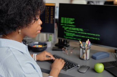 Modern ofiste uygulama için kod yazarken, klavyeye yazı yazan genç Afrikalı Amerikalı yazılım geliştiricisinin kenar görünümü, boşluk kopyala