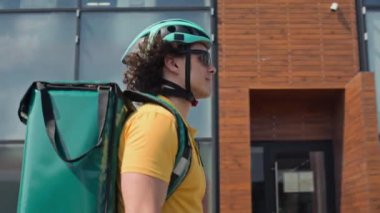 Kafkaslı beyaz kuryenin, yerleşim bölgesinde termal torba içinde erzak dağıtırken çekilen görüntüsü.