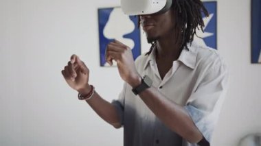 Afro-Amerikan galeri ziyaretçisinin sergi salonundaki aynalı masanın yanında dikilip etrafa bakınırken çekilmiş görüntüsü artırılmış gerçeklikte.