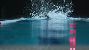 Kapalı havuzda yüzerken serbest stil yüzme tekniği uygulayan yavaş profesyonel yüzücü.