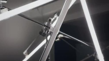 Kavramsal sanat galerisinin karanlık sergi salonunda titreşen metal çubuklar ve floresan tüplerle yaratıcı ışık kurulumunun ayrıntılı görüntüsü
