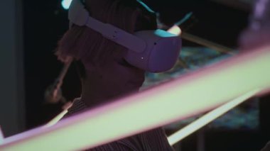 VR gözlüklü genç adam karanlık odada neon lambaların arasında duruyor ve modern Nuh 'un Gemisi Galerisi' nde yükseltilmiş gerçeklikte ışık tesisini keşfediyor.