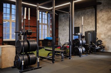 Egzersiz makineleri ve ağırlık eğitim ekipmanları kopyalama alanı olan tavan arası tarzı spor salonunun arkaplan görüntüsü