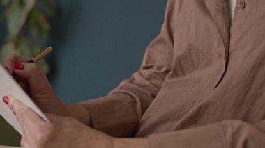 Kafkasyalı empatik kadın psikoloğu yukarı kaldır. Not defterine notlar yaz ve hastanın ofis terapisi sırasında yaşadığı zihinsel sorunları dinlerken başını salla.
